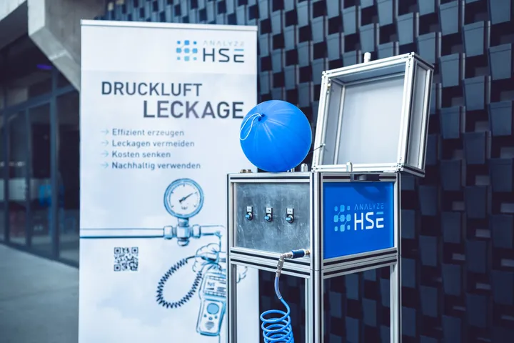 Informationsstand der Analyse HSE GmbH zu Druckluftleckagen mit Messgerät und Poster - Analyze HSE GmbH